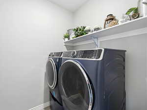 Laundry room featuring washing machine and clothes dryer and baseboards