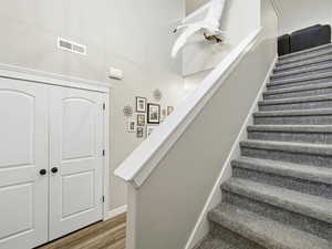 Staircase with wood finished floors and baseboards
