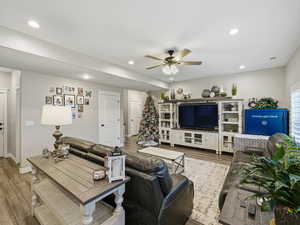 Living area with wood finished floors, ceiling fan, and recessed lighting