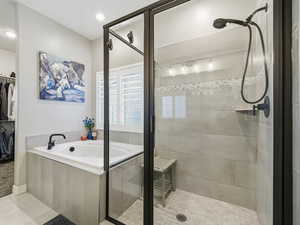 Full bath with a bath, a shower stall, a walk in closet, light tile patterned floors, and recessed lighting