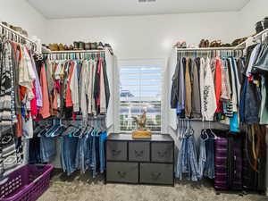 Walk in closet with carpet flooring
