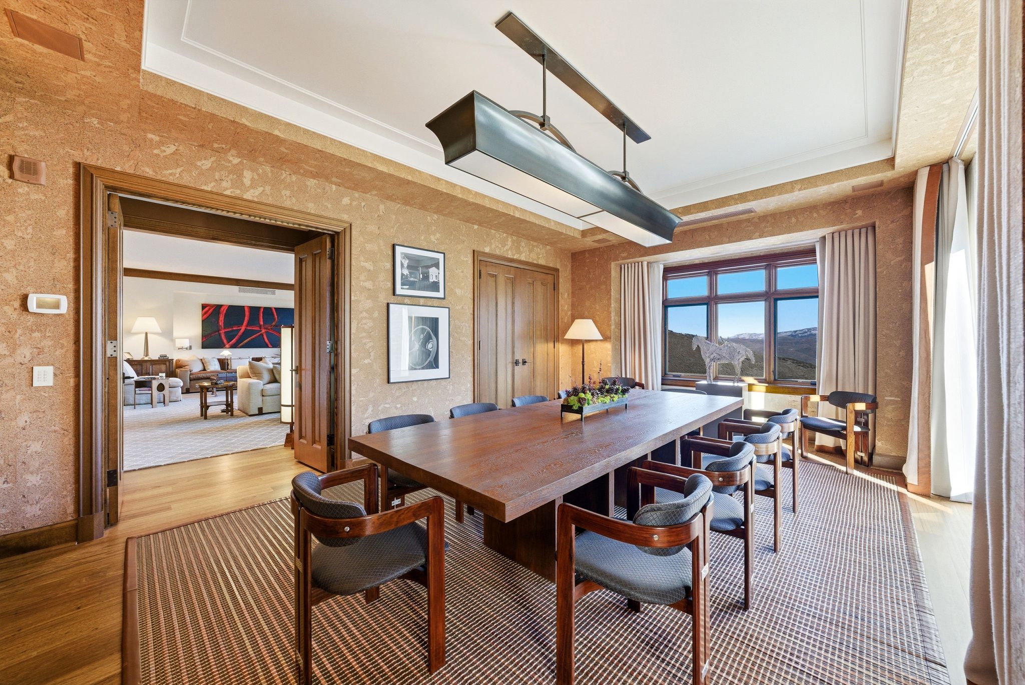 Dining space featuring light wood finished floors, a raised ceiling, and a textured wall