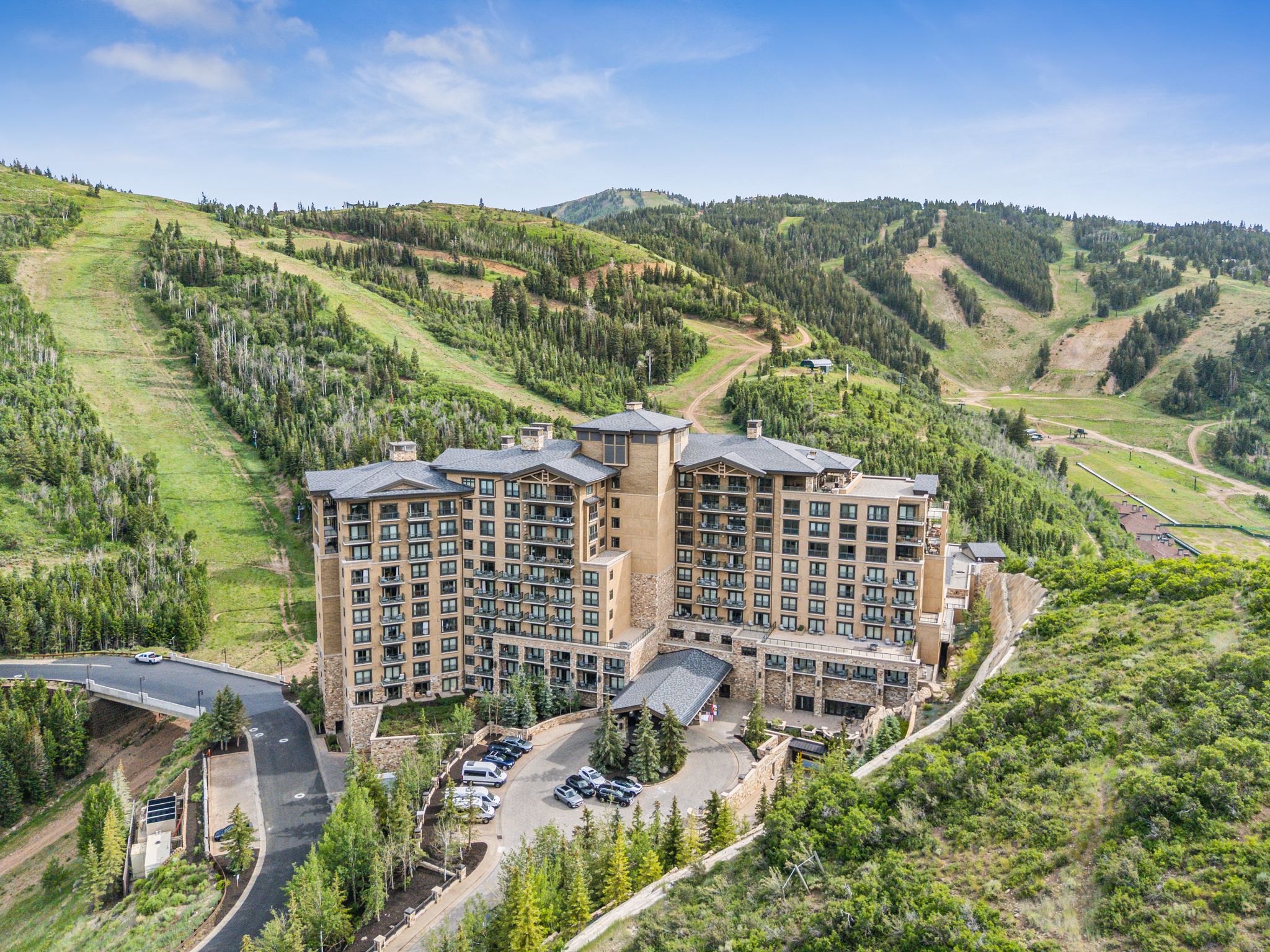 Multi-story building featuring extensive balconies, a stone and stucco facade, and a prominent porte-cochère entrance