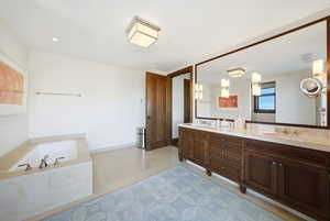 Bathroom featuring double vanity and a bath