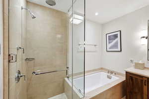 Full bathroom featuring a bath, vanity, a stall shower, and recessed lighting
