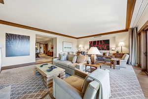 Living area featuring light wood finished floors and crown molding