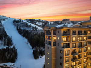 Snow covered property featuring a mountain view and a view of apartment building / complex
