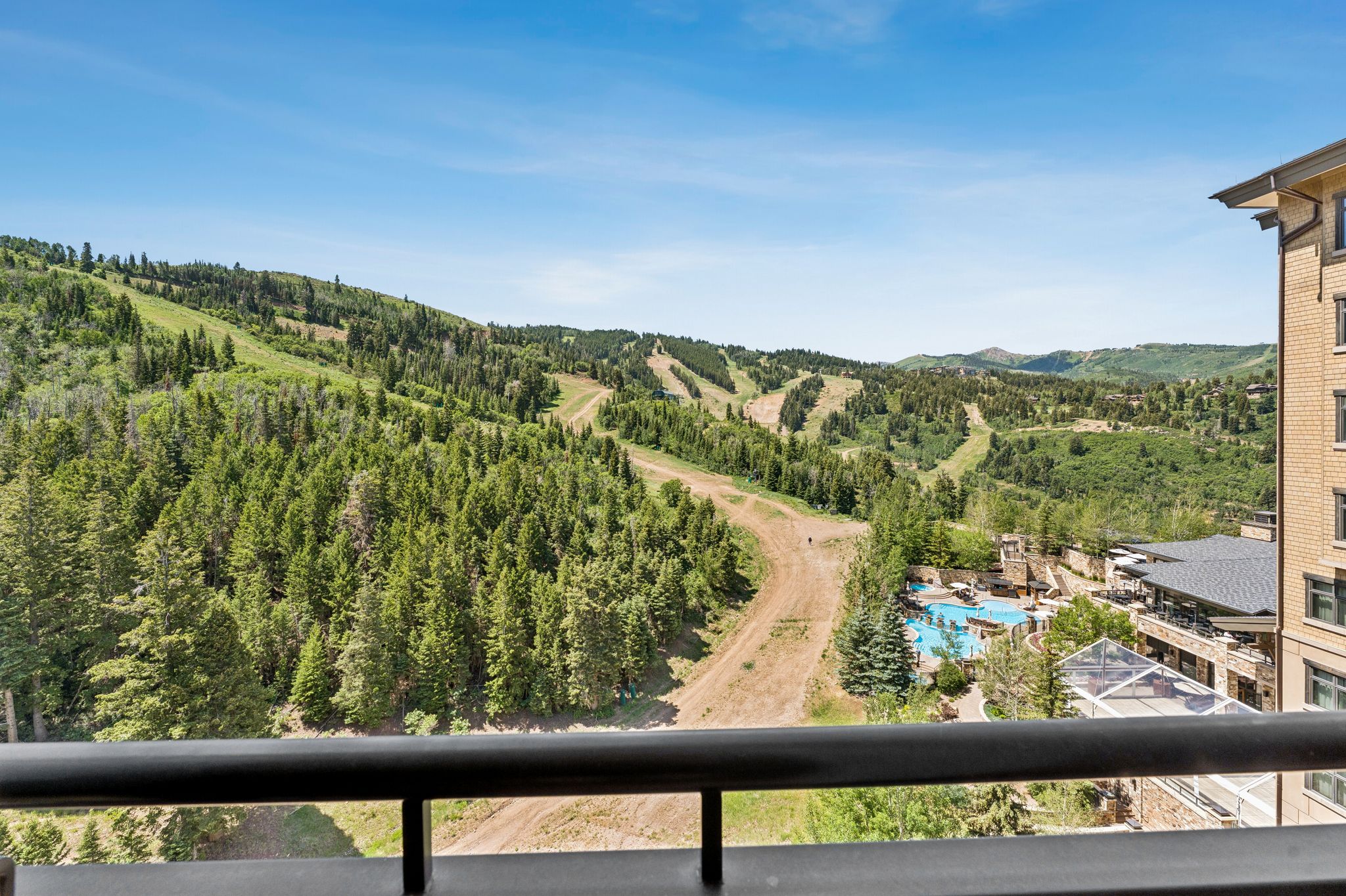 Expansive mountain landscape featuring dense evergreen forests and visible ski slopes
