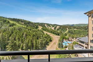 Expansive mountain landscape featuring dense evergreen forests and visible ski slopes