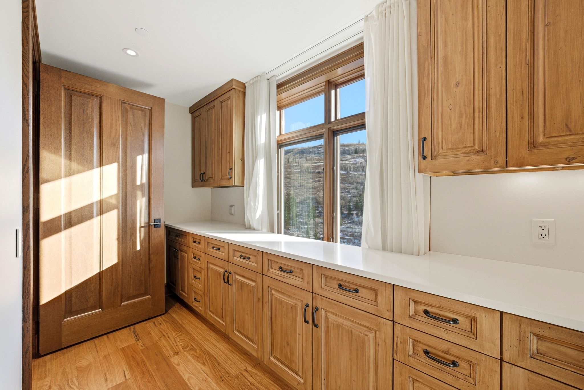 Kitchen with light wood-type flooring, brown cabinets, and recessed lighting
