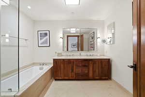 Bathroom with a bath, double vanity, light tile patterned flooring, and recessed lighting