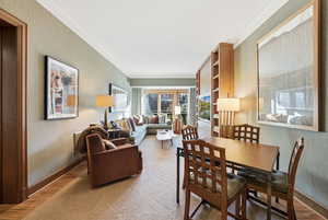 Dining room with ornamental molding and light wood-type flooring