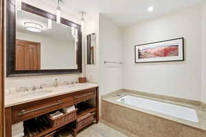 Bathroom featuring double vanity and a bath