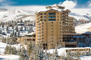Snow covered building with a view of apartment building / complex and a mountain view