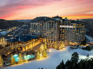 Snow covered building with a view of apartment building / complex, a mountain view, and an outdoor pool