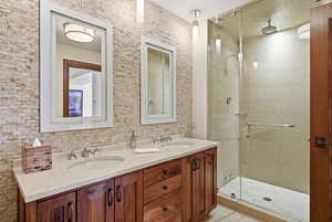 Bathroom featuring double vanity and a stall shower