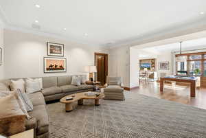 Living area with billiards, crown molding, light wood finished floors, and recessed lighting
