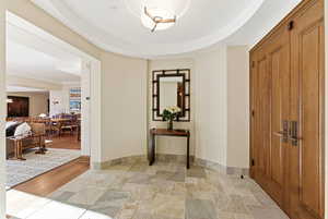 Corridor featuring stone tile flooring and baseboards