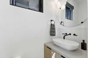 Bathroom featuring vanity and decorative backsplash