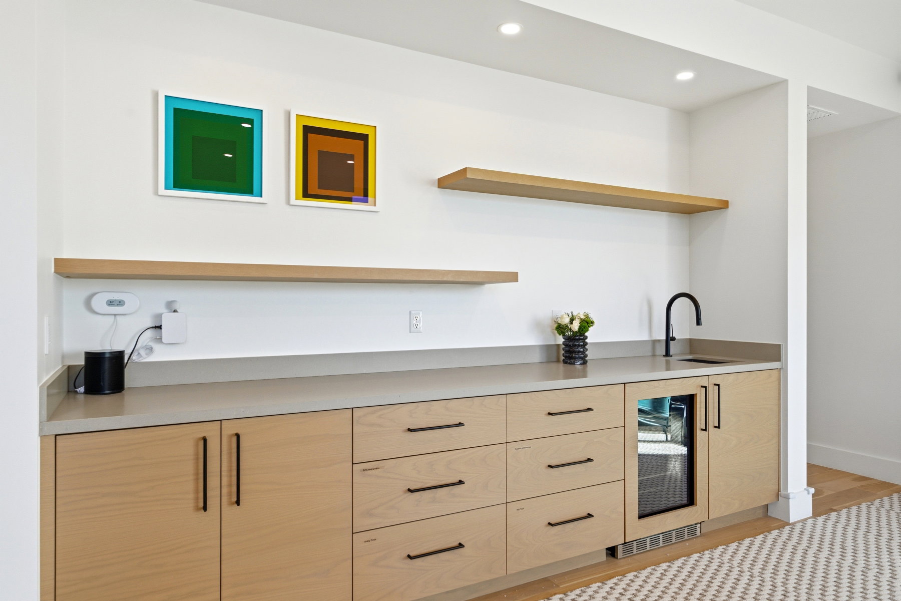 Bar featuring open shelves, light brown cabinets, wine cooler, light countertops, and modern cabinets