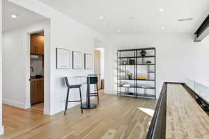 Living area with light wood-style flooring and recessed lighting