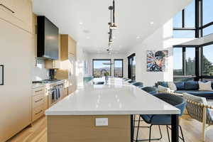 Kitchen featuring modern cabinets, light brown cabinetry, a kitchen bar, a spacious island, and recessed lighting