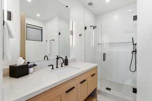 Full bath with a stall shower, vanity, and recessed lighting