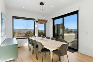 Dining space featuring a mountain view, light wood finished floors, a chandelier, and recessed lighting