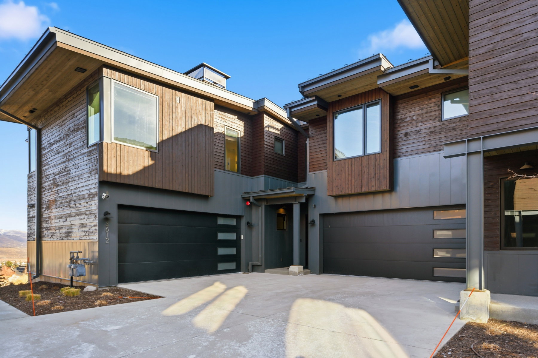 Contemporary house featuring concrete driveway and an attached garage