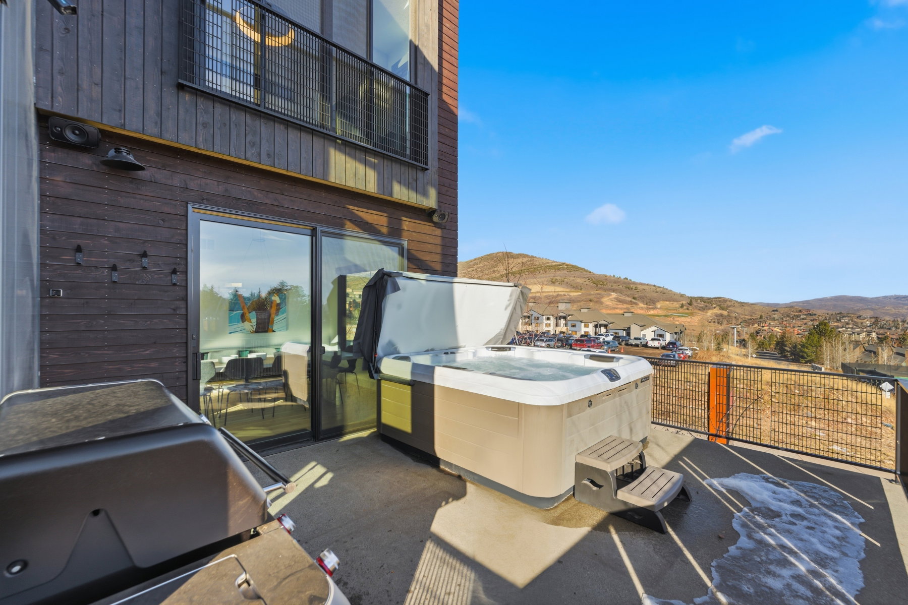 Patio / terrace with a mountain view, a hot tub, and a grill