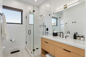 Full bathroom featuring vanity, a shower stall, and light tile patterned floors
