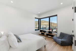 Bedroom with light wood finished floors, recessed lighting, and a mountain view