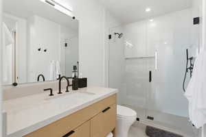 Full bath with vanity, a stall shower, and light tile patterned floors