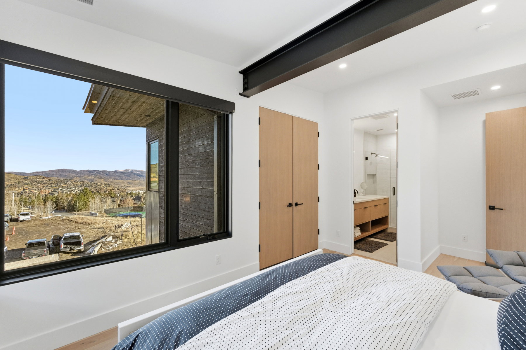 Bedroom with a mountain view, ensuite bath, a closet, and wood finished floors