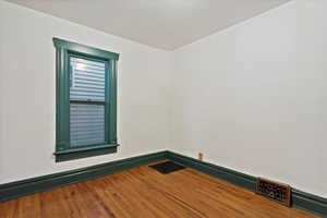 Empty room featuring a baseboard radiator and wood finished floors