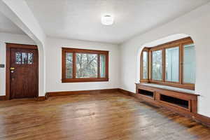 Foyer entrance with arched walkways and hardwood / wood-style floors