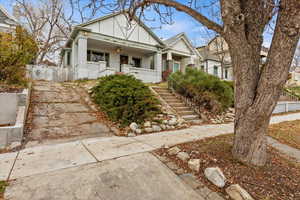 View of front of house with brick siding, stairway, and a porch