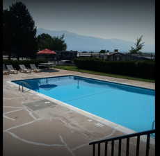 Community pool with a patio area and a mountain view