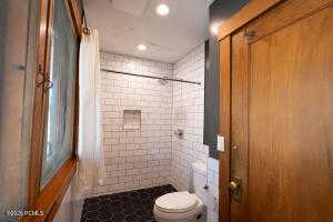 Bath with a shower stall and recessed lighting