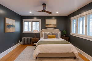 Bedroom featuring radiator, light wood-style flooring, a ceiling fan, and recessed lighting