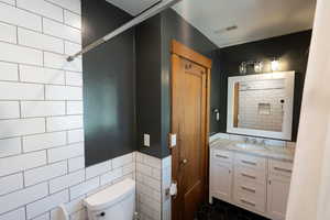 Bathroom with vanity and tile walls
