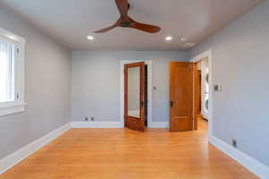 Spare room with light wood-type flooring, stacked washing machine and dryer, recessed lighting, and a ceiling fan