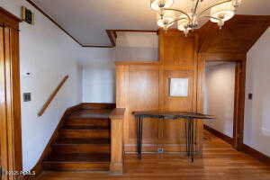 Stairs featuring wood finished floors and a chandelier
