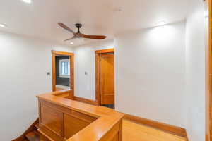 Hallway featuring recessed lighting and an upstairs landing