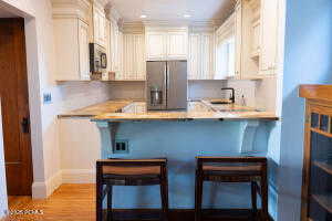 Kitchen featuring a breakfast bar area, stainless steel appliances, light wood finished floors, a peninsula, and recessed lighting