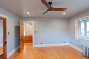 Spare room with radiator, recessed lighting, light wood finished floors, and ceiling fan