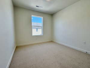 Spare room featuring a textured ceiling and carpet