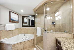 Primary en suite bathroom with soaking tub, spa shower, and double vanity