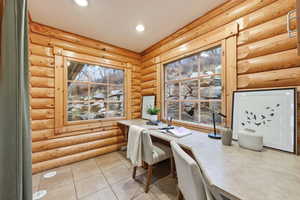Office area with healthy amount of natural light, log walls, light tile patterned flooring, and recessed lighting