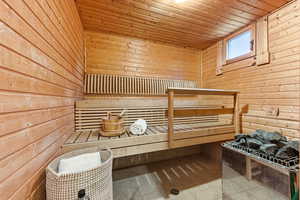 Sauna featuring wood walls, wood ceiling, and tile patterned flooring